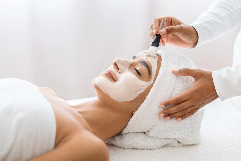 In a moment of tranquility, young indian woman experiences the luxury of a professional facial mask treatment, enhancing her skin's radiance.